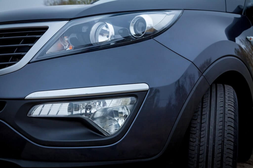 Nahaufnahme eines dunkelblauen Autos mit rechtem Frontscheinwerfer, Kühlergrill und Reifen, ein automatisch gespeicherter Entwurf im eleganten Automobildesign