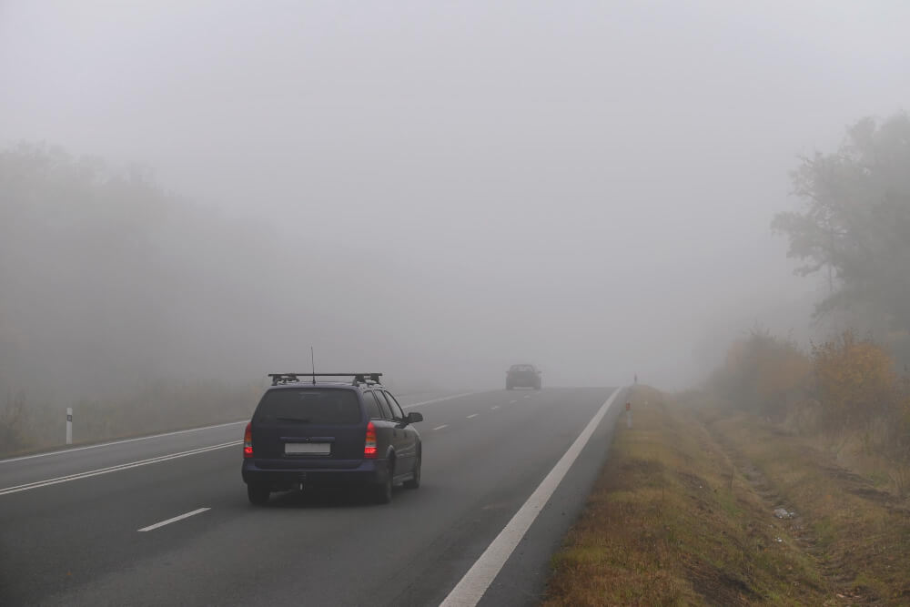Ein Auto fährt bei dichtem Nebel durch die Aller-Niederungen, die Sicht ist schlecht, und vor ihm taucht schemenhaft ein weiteres Auto auf